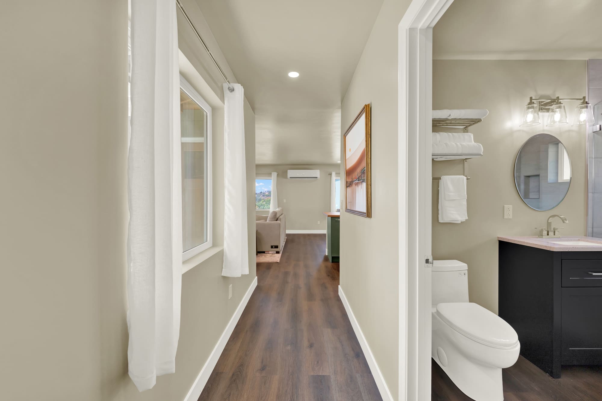 The hall, with the bath opening off it. Towel shelving is built into the wall rather than hung on it.