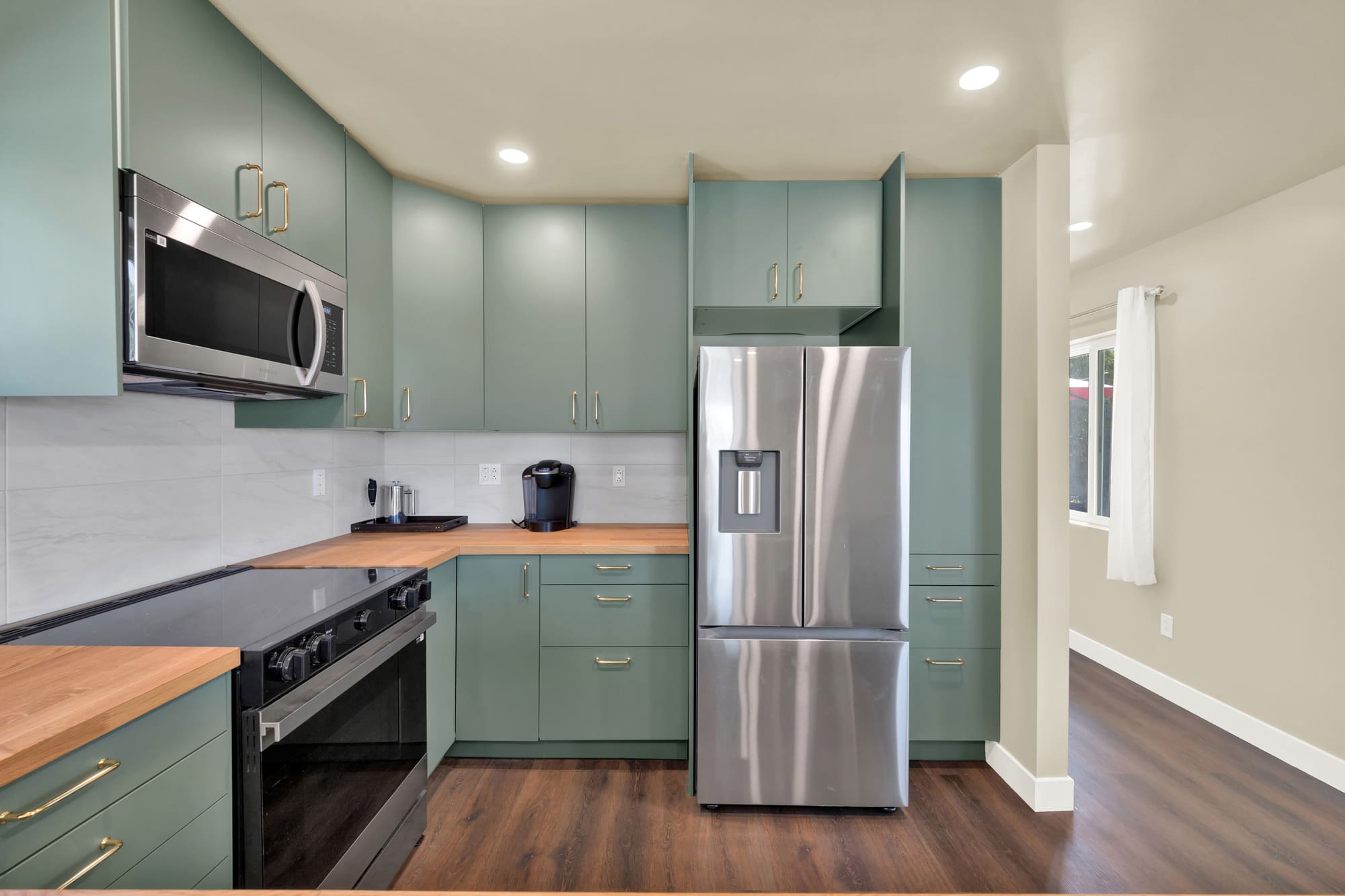 Full-height cabinets flank the refrigerator and carry the pantry storage. In a unit this size, vertical space is the storage.