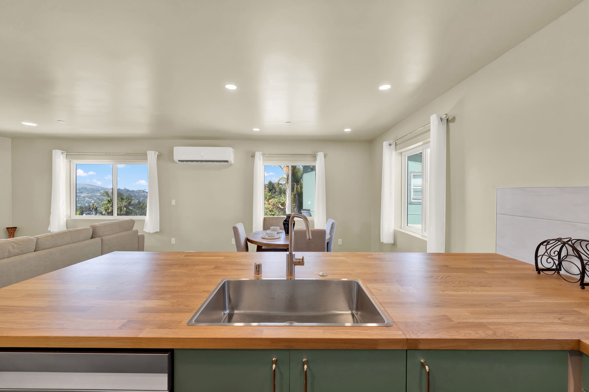 From behind the sink. The wall above the counter was left open to the living room so the canyon view carries the length of the unit.