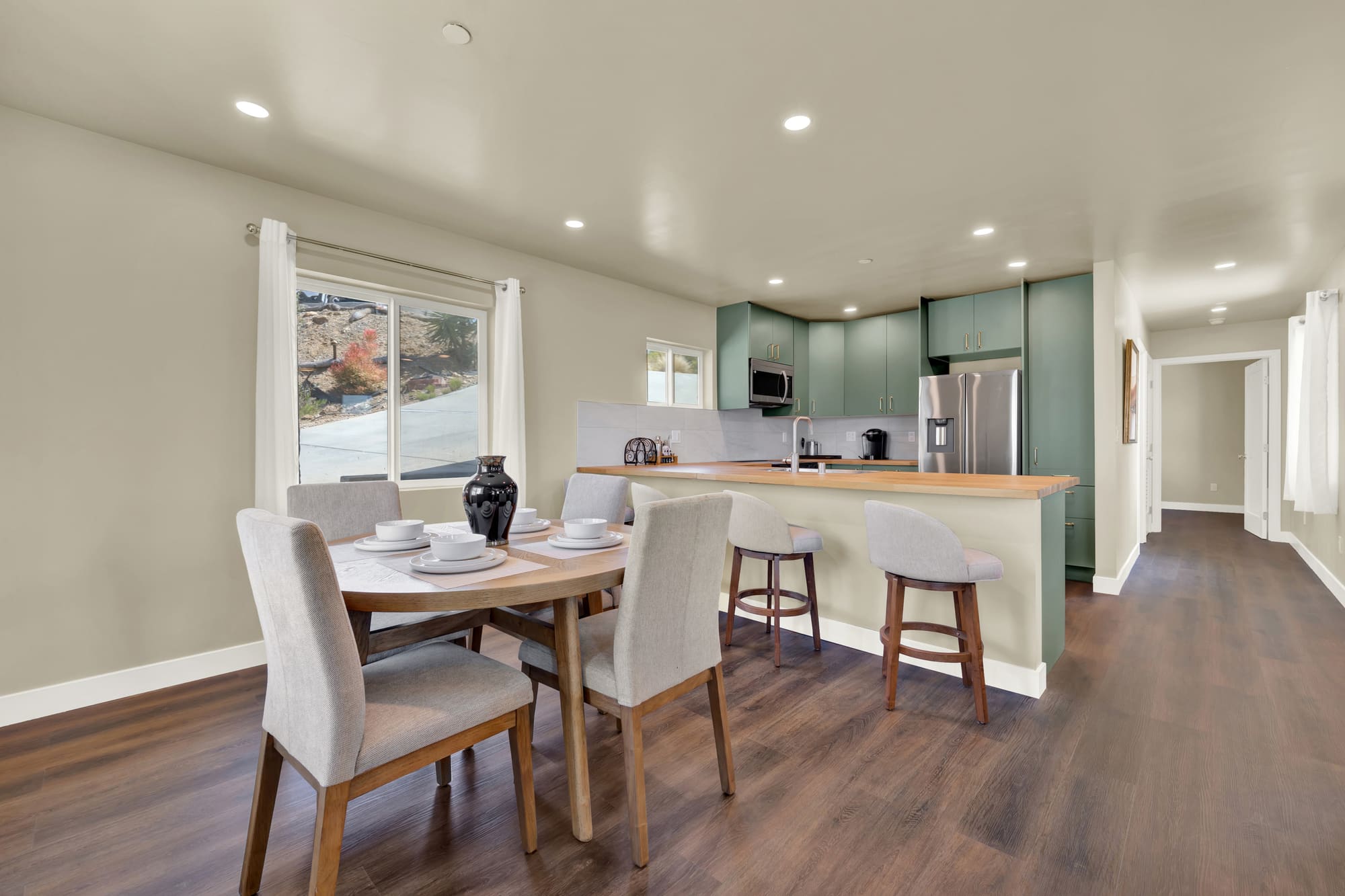 Kitchen and dining read as one space. The peninsula does the dividing instead of a wall — the move that makes a small footprint live large.