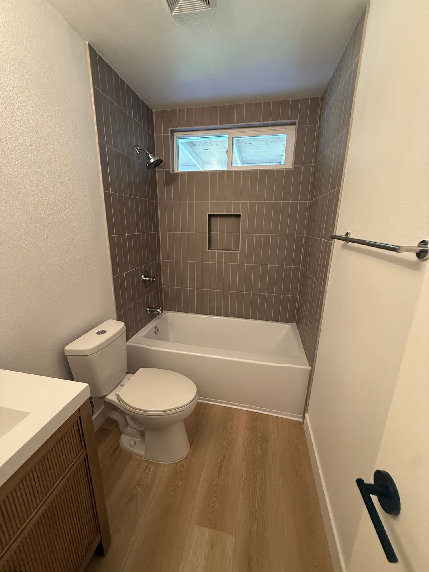 The tub surround in vertical stacked tile with a recessed niche. Stacking the tile this way draws the eye up and makes a small bathroom feel taller.