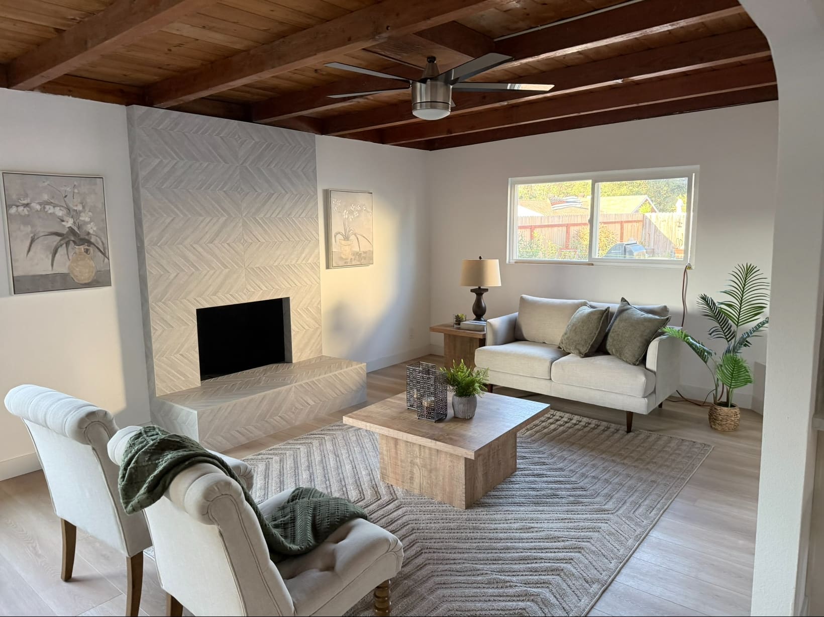 The fireplace runs floor to ceiling in herringbone tile, with the hearth wrapped in the same pattern. The tile was laid out so the pattern centers on the firebox.