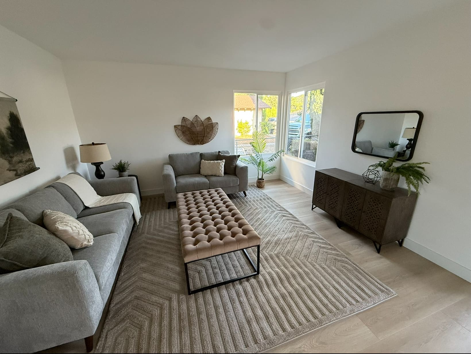 The family room at the front of the house, with corner windows and a flat ceiling — a quieter room than the beamed side.