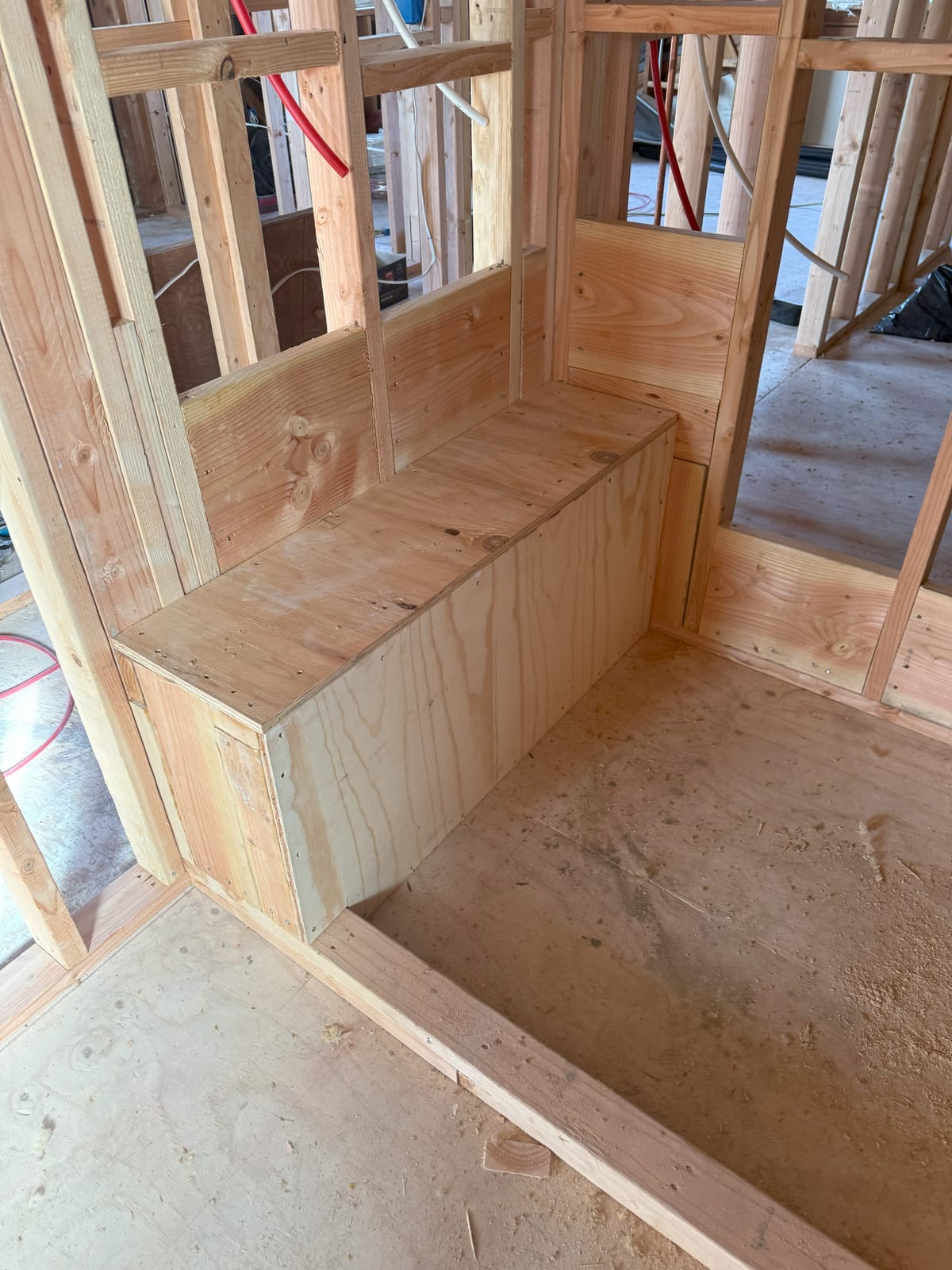 A bathroom roughed in and framed, with the shower base built before any tile or waterproofing goes on.