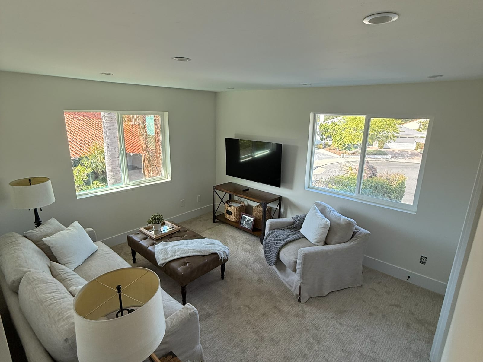 The finished main living room, opened up under a vaulted ceiling with new windows and new carpet.