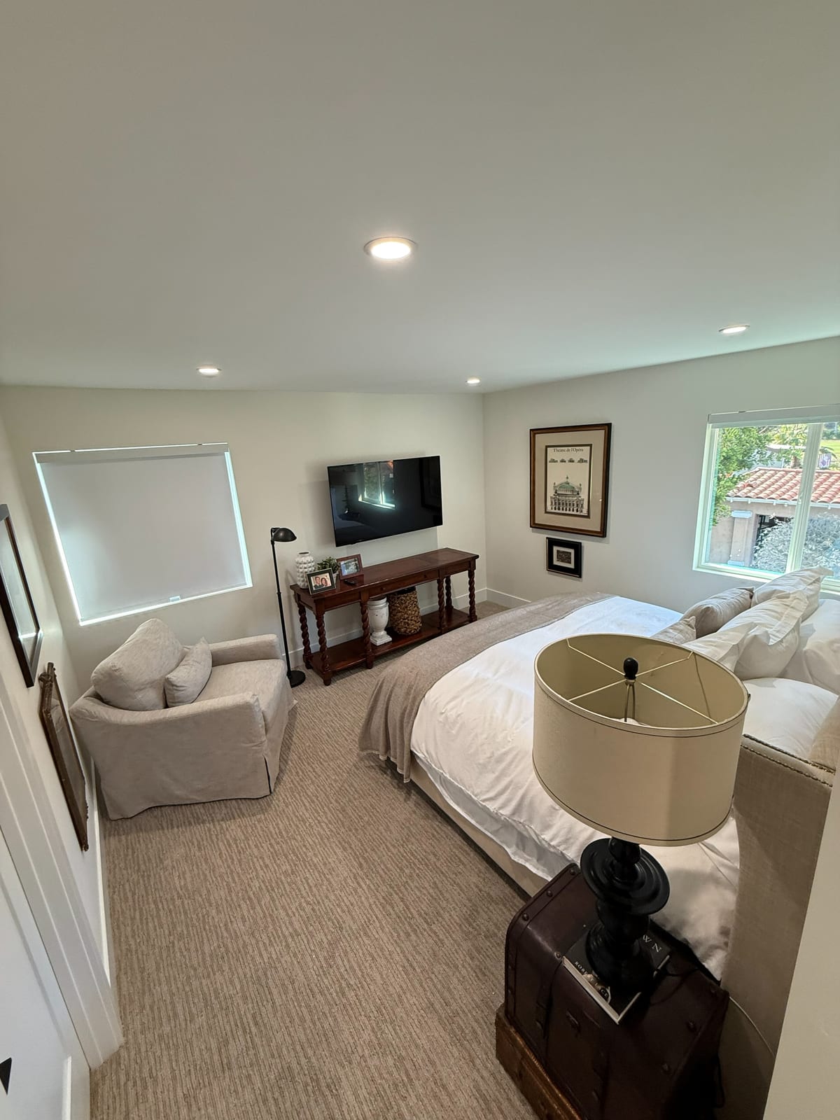 The primary bedroom, staged and finished. New carpet, fresh paint, and windows on two walls.