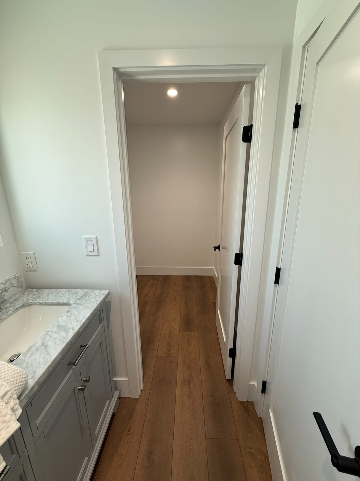 The hallway ties the level together, with a vanity built into the run and the same flooring carried through.